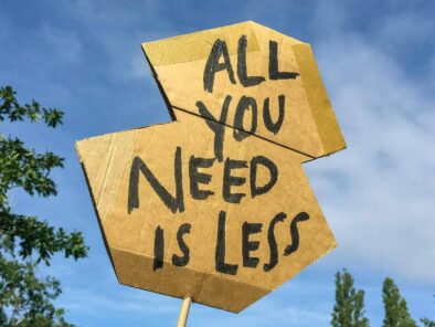 Pappschild mit Spruch All you need is less