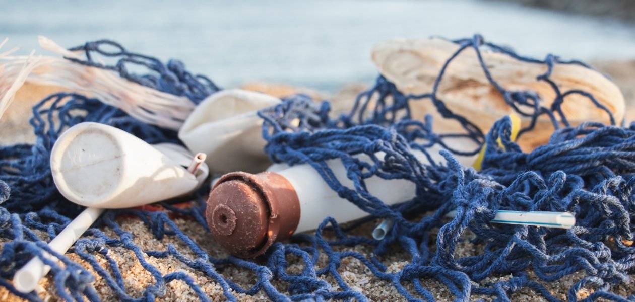 Plastikmüll und Fischernetz aus dem Meer am Strand